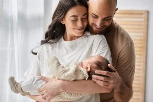 beautiful happy parents hugging and holding their newborn baby boy lovingly, family concept